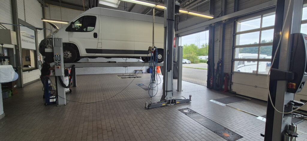 weißer Lieferwagen auf Hebebühne