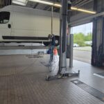 weißer Lieferwagen auf Hebebühne