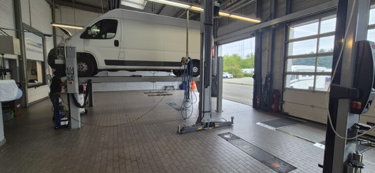 weißer Lieferwagen auf Hebebühne